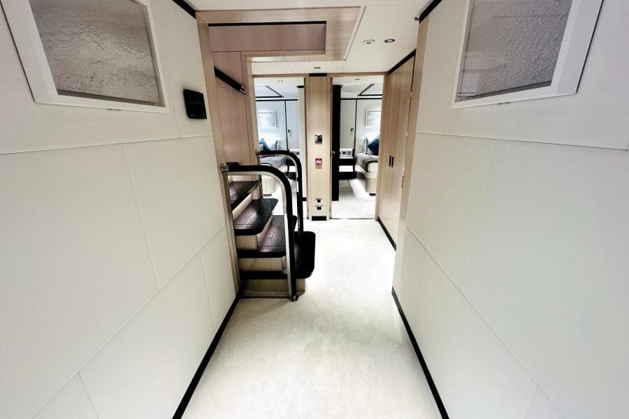 Luxurious interior hallway of 2023 Majesty 120 yacht with modern design and staircase.