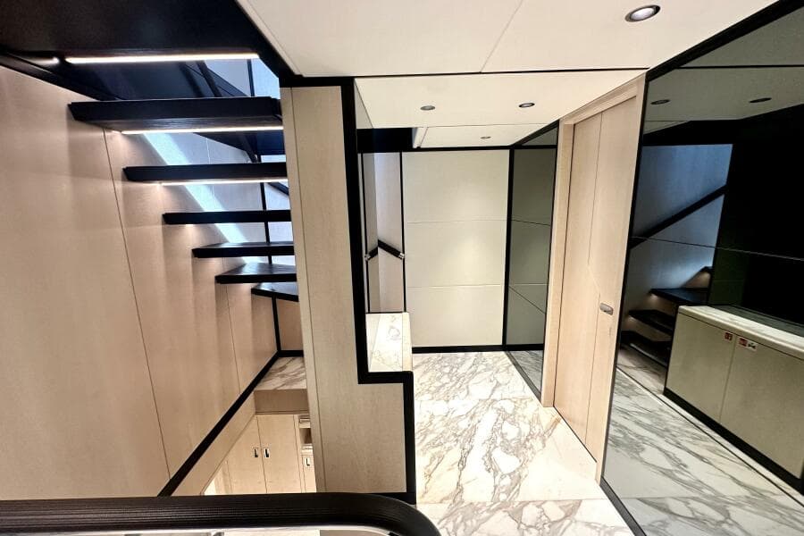 Modern interior of 2023 Majesty 120 yacht with sleek staircase and marble flooring.