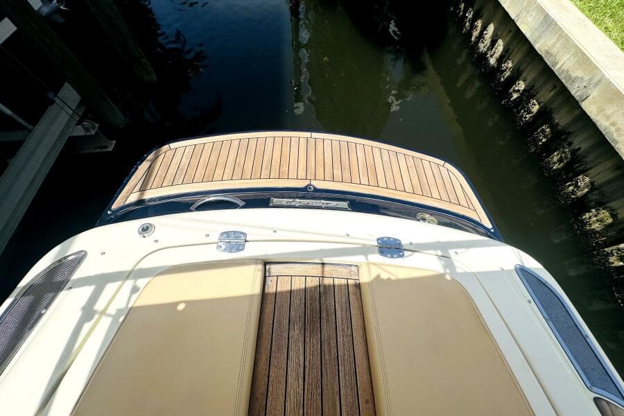 2013 Chris-Craft Corsair 22 boat with teak deck, docked in calm water.