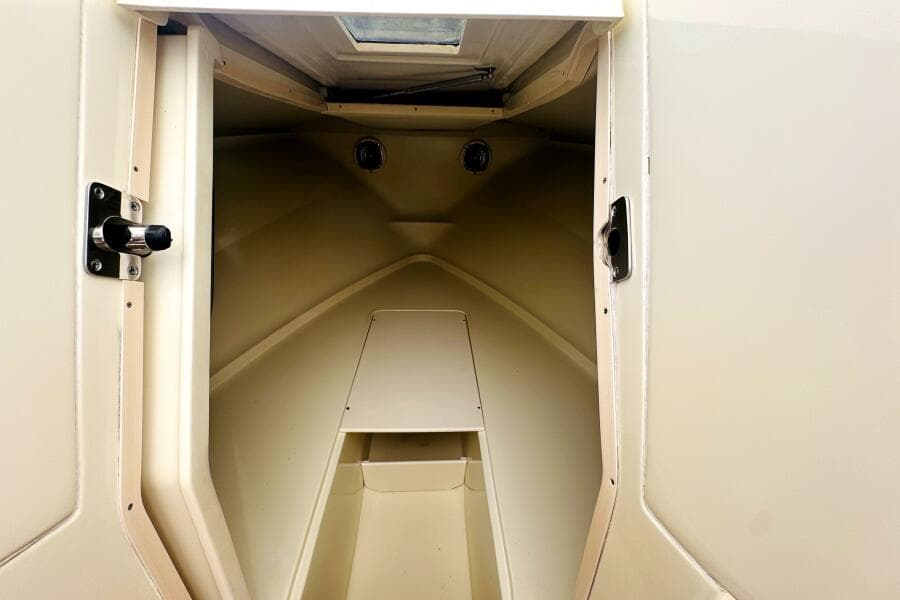 2013 Chris-Craft Corsair 22 cabin interior, featuring a compact, beige design.