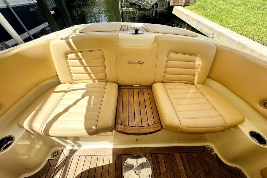 Luxurious 2013 Chris-Craft Corsair 22 boat interior with tan leather seats and wooden flooring.