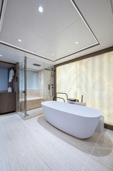 Luxurious Majesty 140 yacht bathroom, 2020 model, featuring modern bathtub and glass shower.