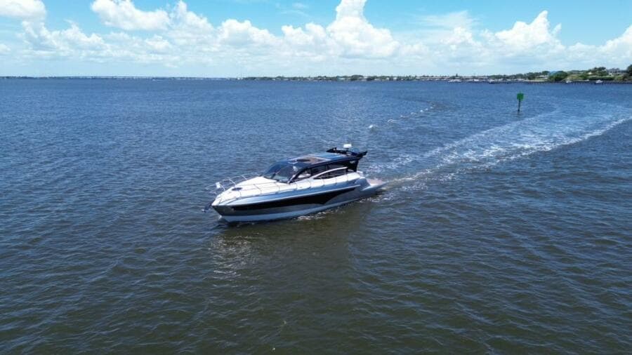 Luxury yacht Real 40 HT cruising on open water under a clear blue sky.