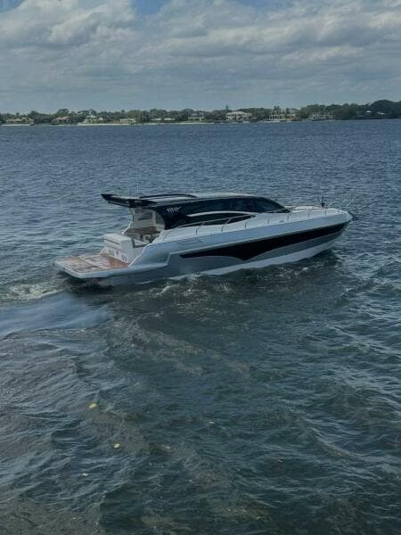 2025 Real 40 HT Luxury yacht cruising on a calm sea under a partly cloudy sky.