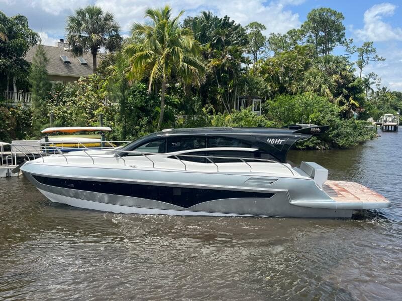 2025 Real 40 HT Luxury yacht on a river, surrounded by lush greenery and palm trees.
