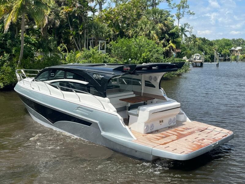 Luxury Real 40 HT yacht cruising on a scenic river, surrounded by lush greenery.