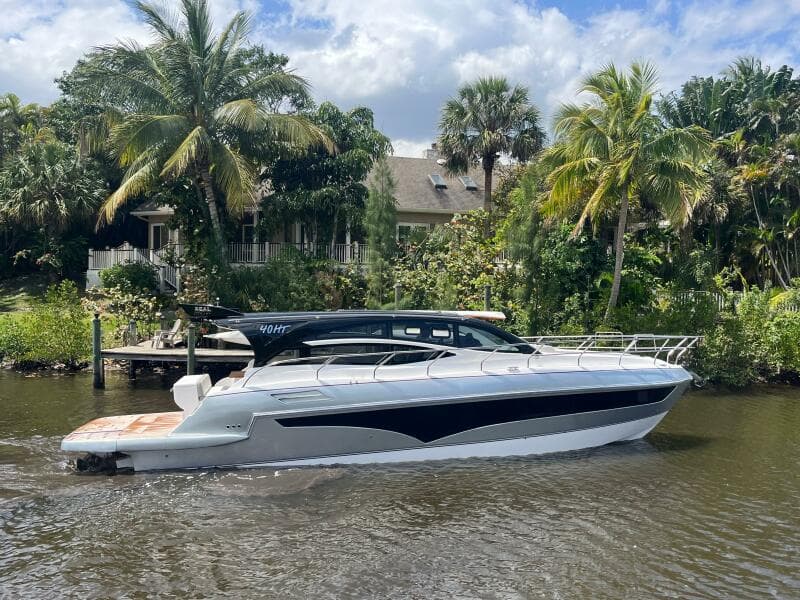 2025 Real 40 HT Luxury yacht cruising on a tropical river with lush greenery.