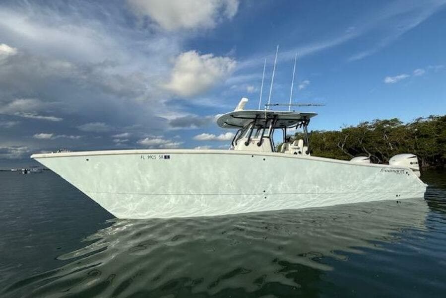 2019 Freeman 34 boat on calm water under a partly cloudy sky.