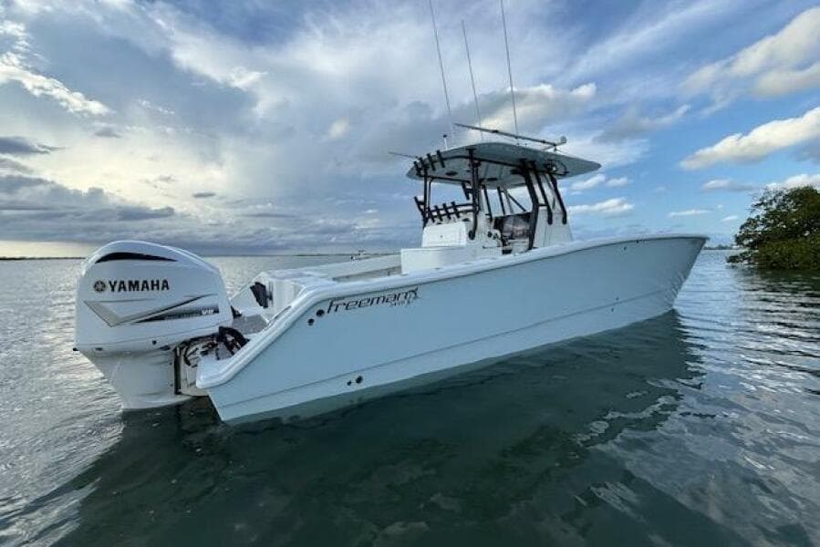 2019 Freeman 34 boat with Yamaha engine on calm water under cloudy sky.