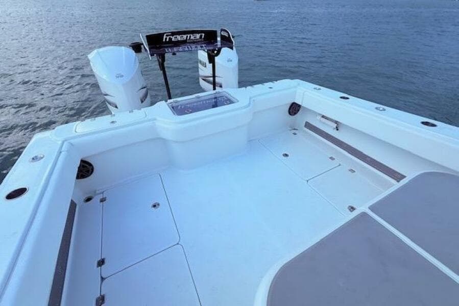 2019 Freeman 34 boat deck with twin engines on calm water.