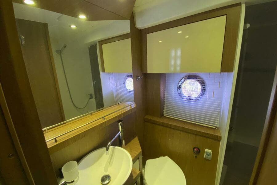 Bathroom interior of 2014 Beneteau Gran Turismo 44 yacht, featuring sink, mirror, and porthole window.