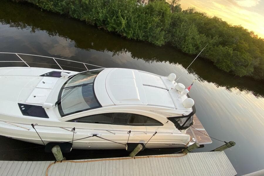 2014 Beneteau Gran Turismo 44 yacht docked by a serene riverbank at sunset.