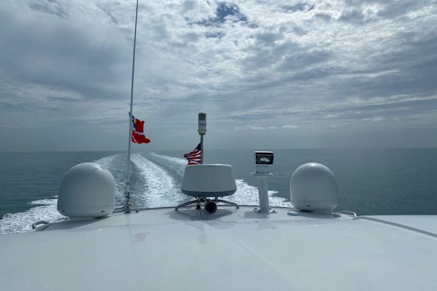 Beneteau Gran Turismo 44 yacht cruising on open sea, 2014 model, with flags flying.