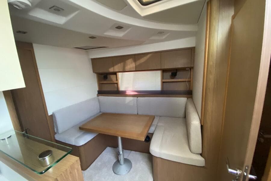 2014 Beneteau Gran Turismo 44 interior with cozy dining area and wooden cabinetry.