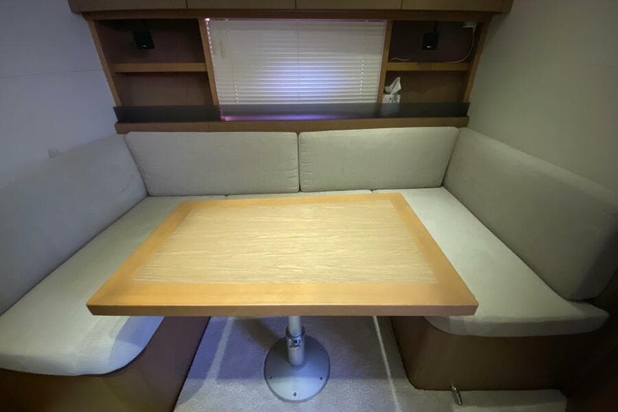 Cozy seating area with table in 2014 Beneteau Gran Turismo 44 yacht interior.