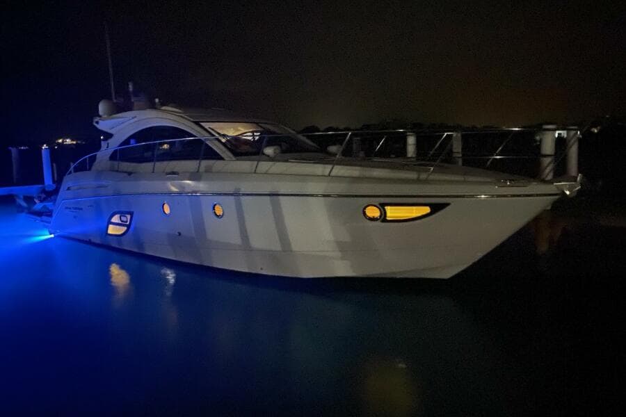 2014 Beneteau Gran Turismo 44 yacht illuminated at night with blue underwater lights.