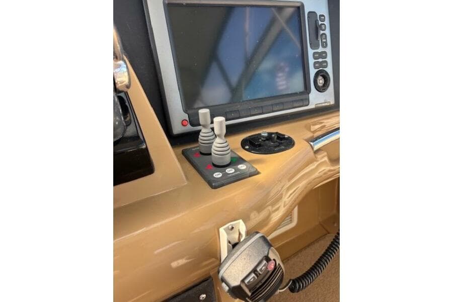Control panel of 2004 Carver 466 Motor Yacht with navigation screen and joystick controls.