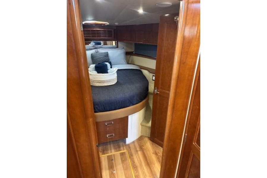 Luxurious cabin interior of 2004 Carver 466 Motor Yacht with wood finish and cozy bedding.