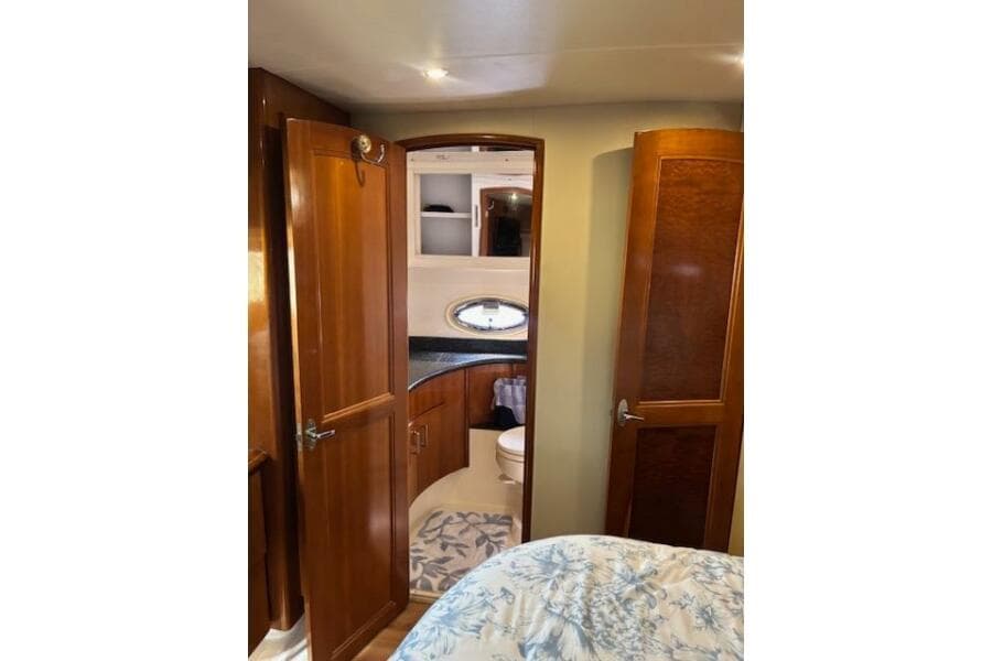 Interior of 2004 Carver 466 Motor Yacht with wooden cabinetry and bathroom view.