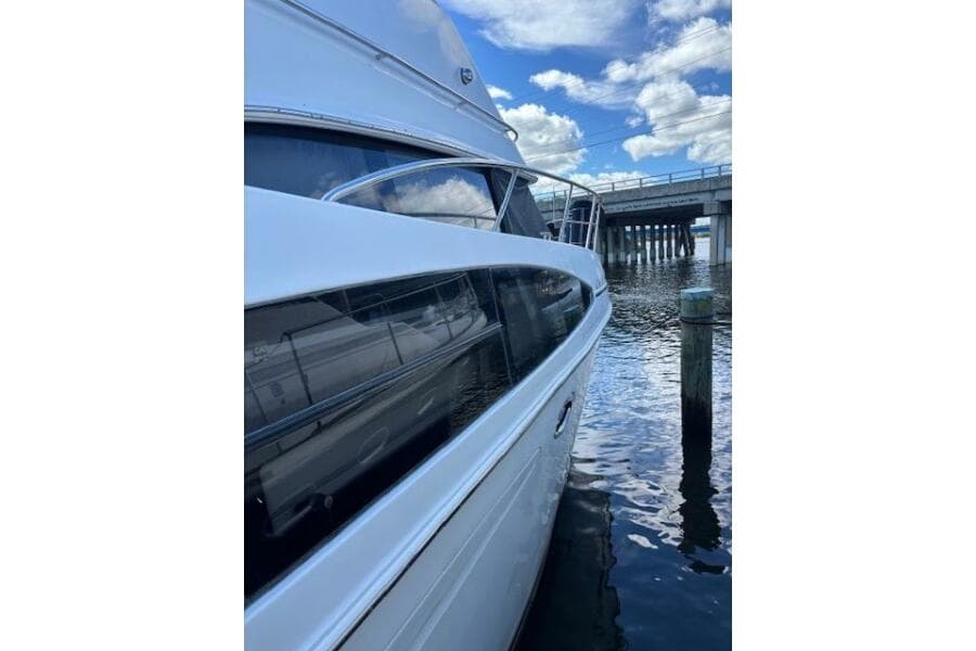 2004 Carver 466 Motor Yacht docked near a bridge under a blue sky.
