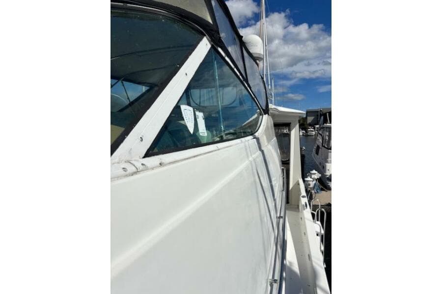 2004 Carver 466 Motor Yacht side view with clear skies and marina background.