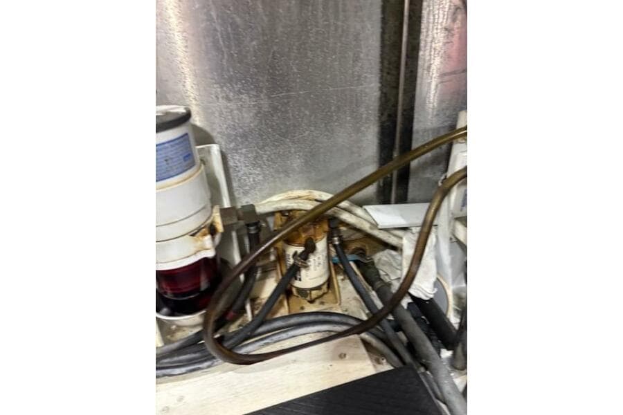 Engine room of 2004 Carver 466 Motor Yacht with visible fuel filter and hoses.