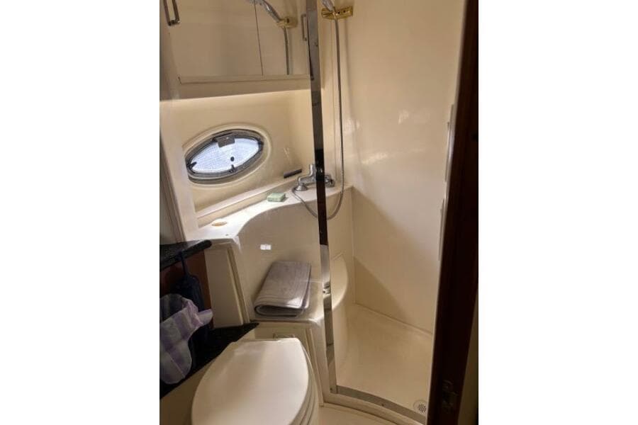 Bathroom interior of 2004 Carver 466 Motor Yacht with shower and porthole window.