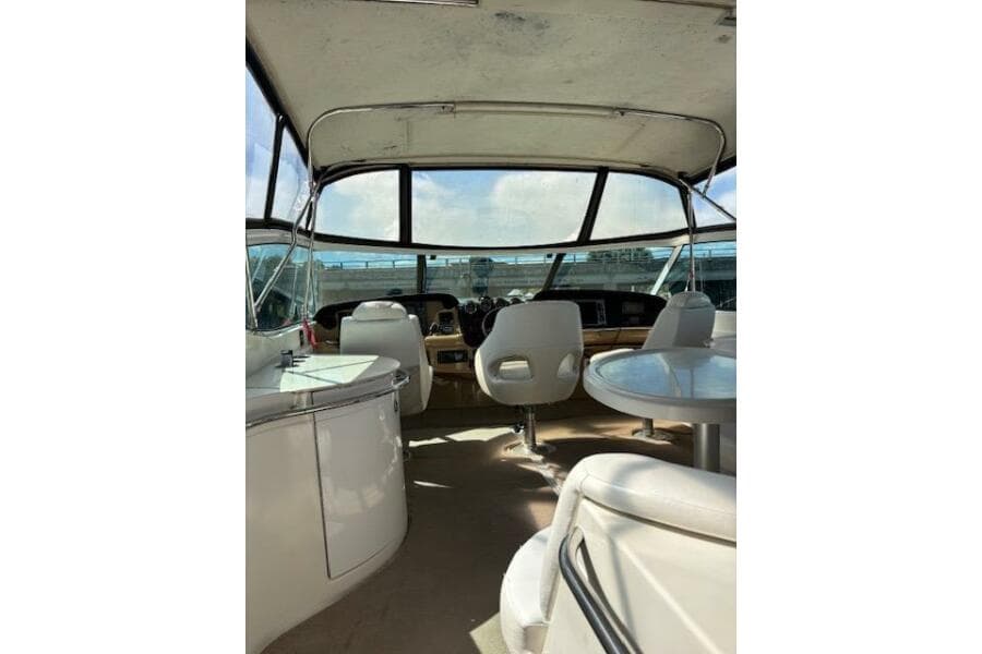 2004 Carver 466 Motor Yacht interior with helm, seating, and panoramic windows.
