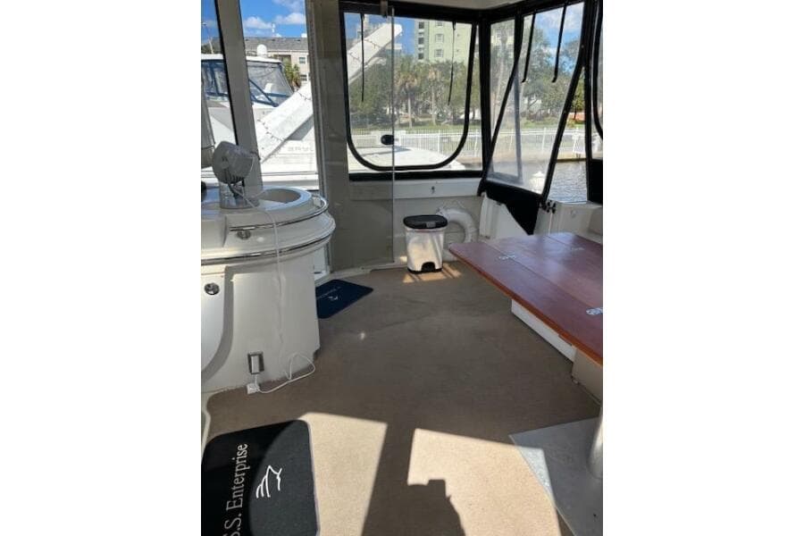 Interior of 2004 Carver 466 Motor Yacht with seating and windows, docked by water.