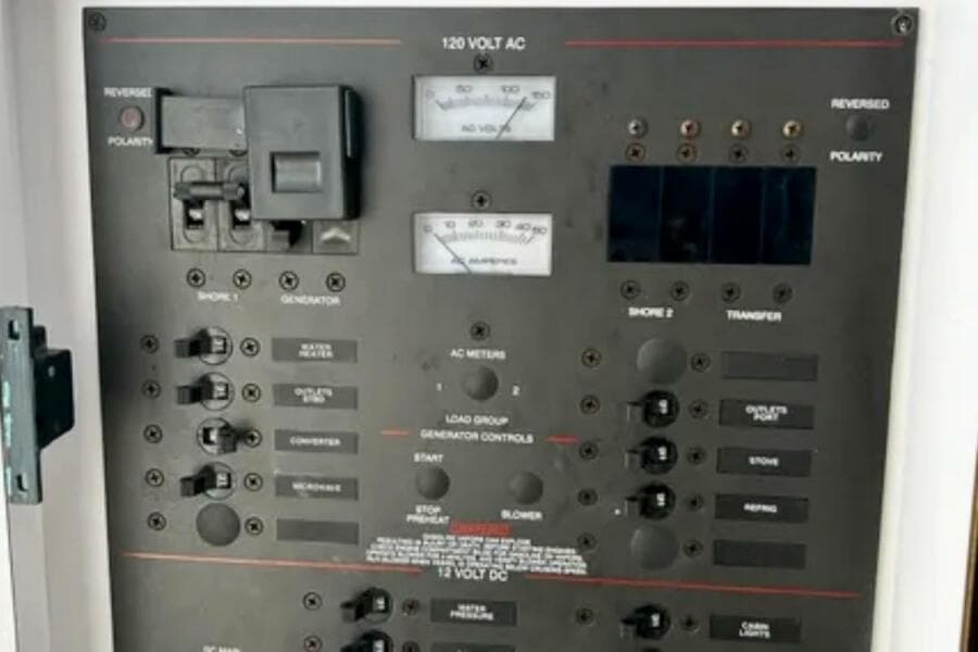 Electrical control panel on a 2002 Wellcraft 290 Coastal boat, featuring various switches and meters.